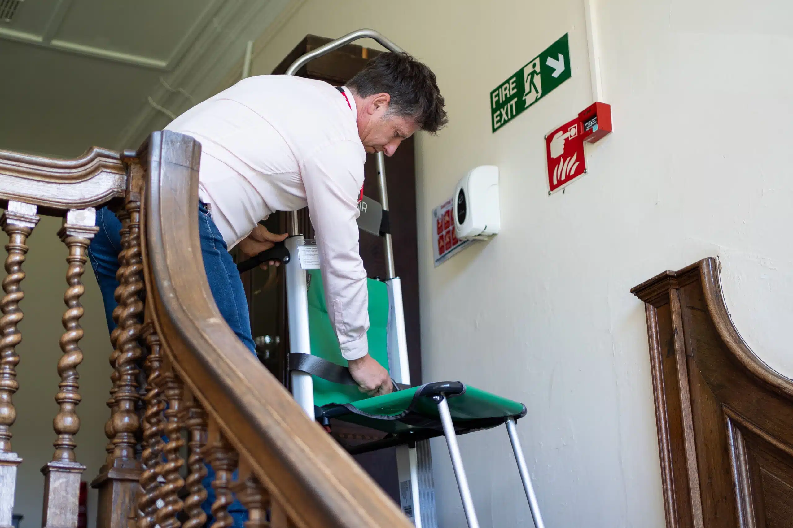 Chris from The Evacuation Company demonstrating evacuation equipment on a staircase.