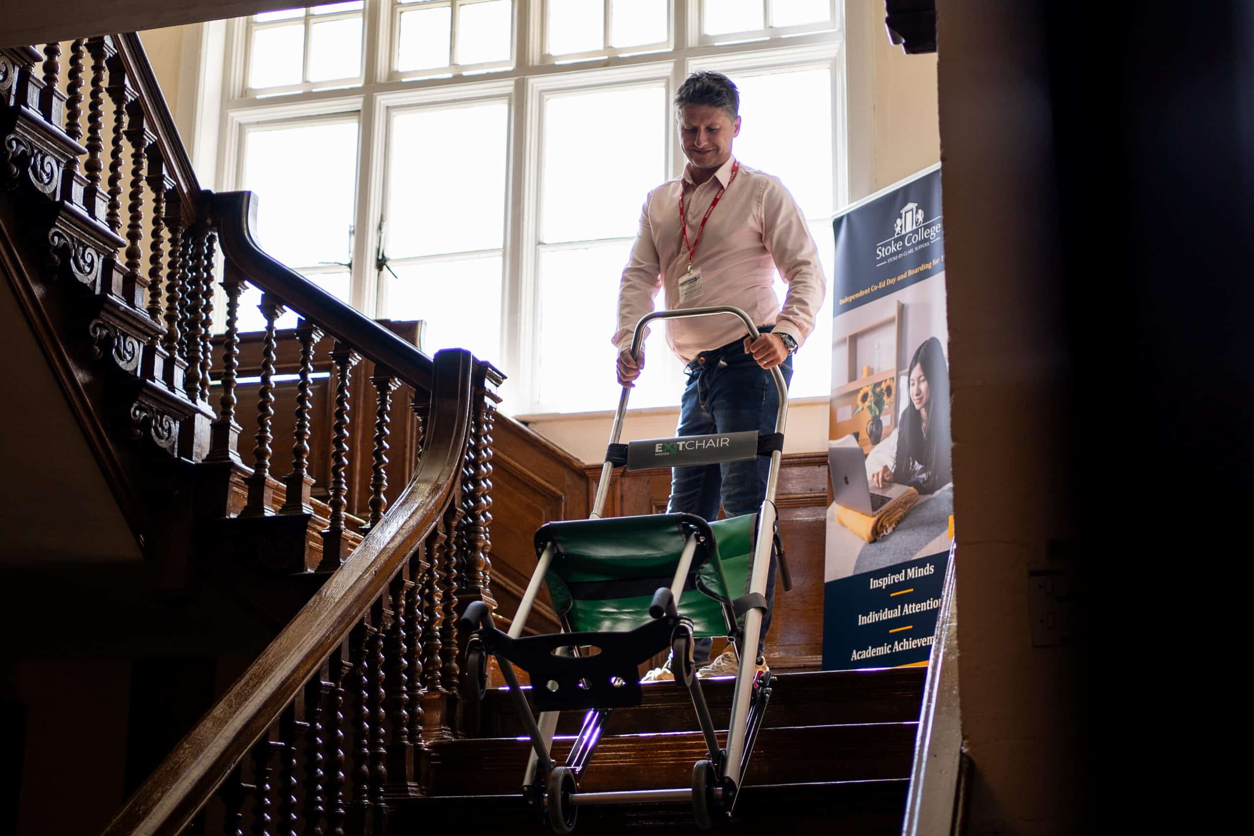 Chris from The Evacuation Company demonstrating evacuation equipment on a staircase.